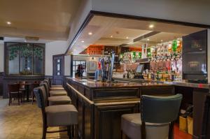 a bar with a row of chairs in a restaurant at Thrums Hotel, Kirriemuir in Kirriemuir