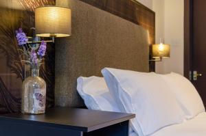 a bed with pillows and a vase on top of it at Thrums Hotel, Kirriemuir in Kirriemuir