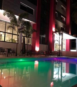 ein Schwimmbad vor einem Gebäude in der Nacht in der Unterkunft Hotel L'Adresse Dakar in Dakar