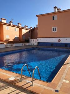 una piscina de agua azul frente a un edificio en Blue relax Candelaria, en Candelaria