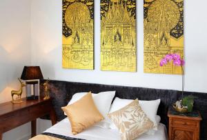 a bedroom with yellow and black art on the wall at Chez Madame Cailleau in Houlgate