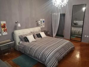 フォリーニョにあるa casa di Narciso e Margheritaのベッドルーム1室(シャンデリアと鏡付きのベッド1台付)
