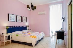 1 dormitorio con cama, mesa y lámpara de araña en BB Augusteo, en Nápoles