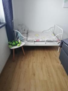 a small bed in a room with a wooden floor at Ferienwohnung Burry in Kapellen-Drusweiler