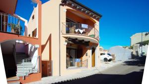 a building with balconies and a dog on a balcony at Le Gemelle di Cairoli in Santa Teresa Gallura