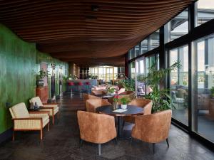 a restaurant with tables and chairs and windows at Radisson Blu Caledonien Hotel, Kristiansand in Kristiansand