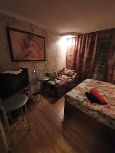 een slaapkamer met een bed, een bank en een tafel bij House Hotel Apartments 3 in Rivne