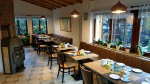 a restaurant with wooden tables and a wood stove at Pension Body Sun in Niesky