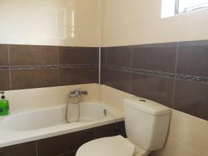 a bathroom with a white toilet and a bath tub at MAREMARI VILLA in Ayía Marína +30 photos