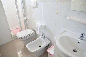 Baño blanco con aseo y lavamanos en Affittacamere San Francesco, en Matera