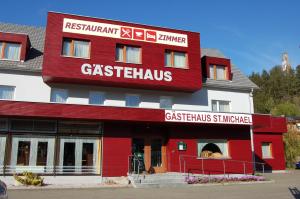 un edificio rojo y blanco con un restaurante gstaitz en Gästehaus St.Michael, en Sankt Michael in Obersteiermark