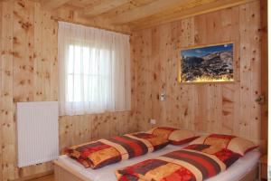 1 dormitorio con 2 camas en una pared de madera en B&B Ciasa Brüscia, en San Vigilio Di Marebbe