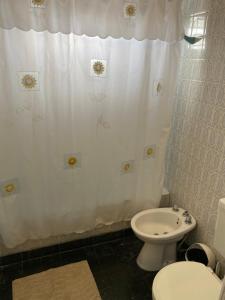 a bathroom with a toilet and a shower curtain at Departamento Ezeiza Centro in Ezeiza +16 photos