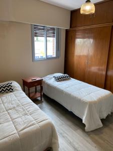 a bedroom with two beds and a window at Departamento Ezeiza Centro in Ezeiza