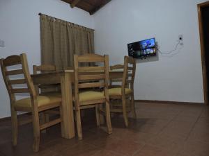 Un comedor con mesa y sillas y un televisor. en El Cántaro, en San Rafael