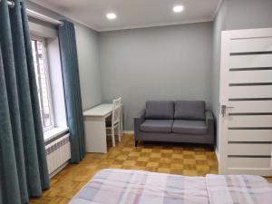 a bedroom with a bed and a chair and a window at Apartment on Oloy 11 in Tashkent