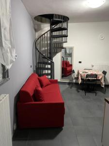 sala de estar con sofá rojo y escalera de caracol en BICOCCA APPARTAMENTI en Milán