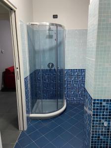 y baño con ducha de azulejos azules. en BICOCCA APPARTAMENTI en Milán
