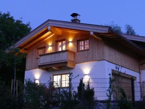 a house with a balcony with lights on it at Bodenschneid Suiten Neureuthblick in Kreuth