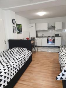 Zimmer mit einem Bett und einer Küche mit weißen Schränken in der Unterkunft DM Apartment in Triberg