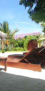 eine hölzerne Bank, die auf der Straßenseite sitzt in der Unterkunft Faima Fishing Lodge at Daravandhoo in Baa-Atoll