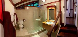 a bathroom with a shower and a toilet and a sink at Namuwoki Lodge in Puerto Viejo
