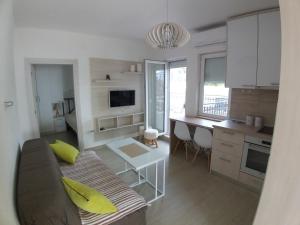 a living room and kitchen with a couch and a table at Apartman Dajoda 1 in Bijela