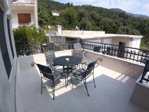 a patio with a table and chairs on a balcony at Apartman Dajoda 1 in Bijela +1 photo