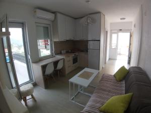 a living room with a couch and a kitchen at Apartman Dajoda 1 in Bijela