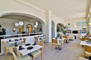 un restaurante con mesas y sillas en una habitación en Golf Hotel, en Bandol