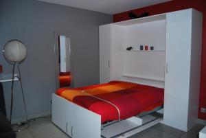 1 dormitorio con 1 cama en una habitación blanca en Appartement, avec piscine privative et parking, à 15 minutes à pied du centre ville et à 20 mn de la mer, en Montpellier