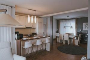 cocina y sala de estar con mesa y sillas en Pool Apartments Lucija, en Novalja