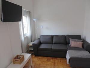 salon z kanapą i telewizorem w obiekcie Alvalade Inn w Lizbonie