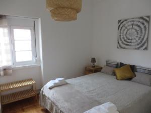 a white bedroom with a bed and a window at Alvalade Inn in Lisbon