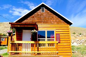 ein kleines Holzhaus mit einer Veranda und einem Fenster in der Unterkunft Yellowstone's Treasure Cabins in Gardiner