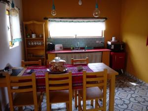 eine Küche mit einem Holztisch mit Stühlen und einer Küche in der Unterkunft Los Remenizos Cabañas de Montaña in Belén