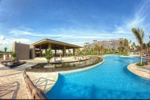 a pool at a resort with blue water at Departamento en La Isla Acapulco Torre H in Acapulco
