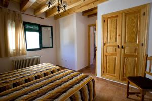 1 dormitorio con cama, ventana y puerta en El Rincón de Uña, en Uña