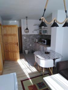 cocina y sala de estar con mesa en una habitación en Apartments Durmitor, en Žabljak