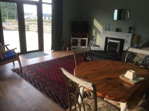 a dining room with a wooden table and a fireplace at Cosy rural self catering annex in Magherafelt