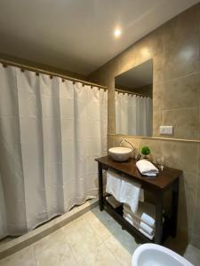 La salle de bains est pourvue d'un lavabo et d'un miroir. dans l'établissement Hotel y Cabañas Las Marías, à El Calafate