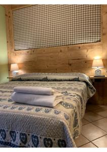 ein Schlafzimmer mit einem Bett mit Handtüchern darauf in der Unterkunft Rêve en ville in Aosta