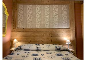 ein Schlafzimmer mit einem Bett mit einem Kopfteil aus Holz in der Unterkunft Rêve en ville in Aosta