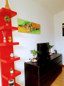 Camera con scrivania, TV e scaffali rossi. di Oliver Suite Plaza Mayor a Madrid