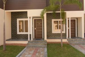 a house with two doors and a palm tree at Tranquil Park in Puducherry