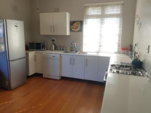 una cucina con mobili bianchi e un frigorifero bianco di Turtle Creek - Leatherback a Umkomaas