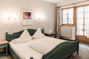 sypialnia z zielonym łóżkiem z białymi poduszkami w obiekcie Alt-Kaisers w Solden