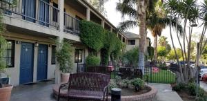 a building with benches in front of a building at Sierra Crossing Motel in Bloomington