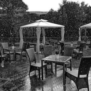 a patio area with tables, chairs and umbrellas at Relais Casa Orter in Risano