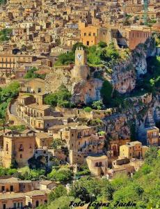 un villaggio con una torre dell'orologio su una montagna di Le Rose di Modica a Modica